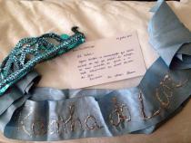 Faixa e coroa confeccionadas por Hildete Pereira. Com elas Carmen desfilou na passeata de 8 de maro de 1983, incorporando a personagem "A rainha do lar"! na mo direita um espanador, na esquerda um "Cesto de Vida", com utenslios domsticos. Foto de Eunice Gutman, confiada ao Acervo Carmen da Silva